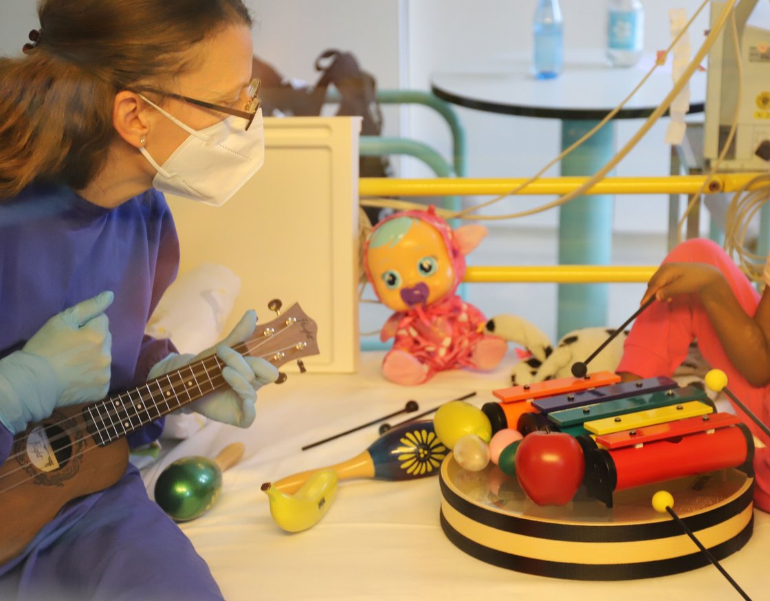 Die Musiktherapeutin am Patientenbett mit Gitarre