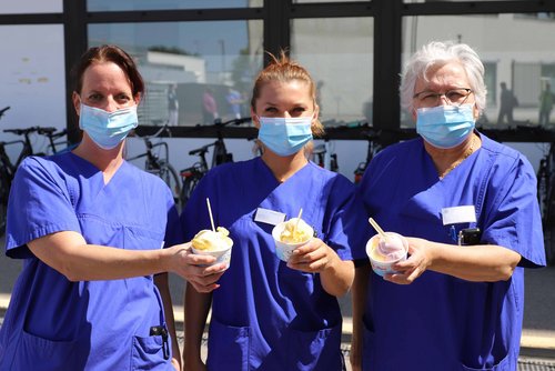 Drei Mitarbeiterinnen zeigen das Eis, das sie sich gerade abgeholt haben