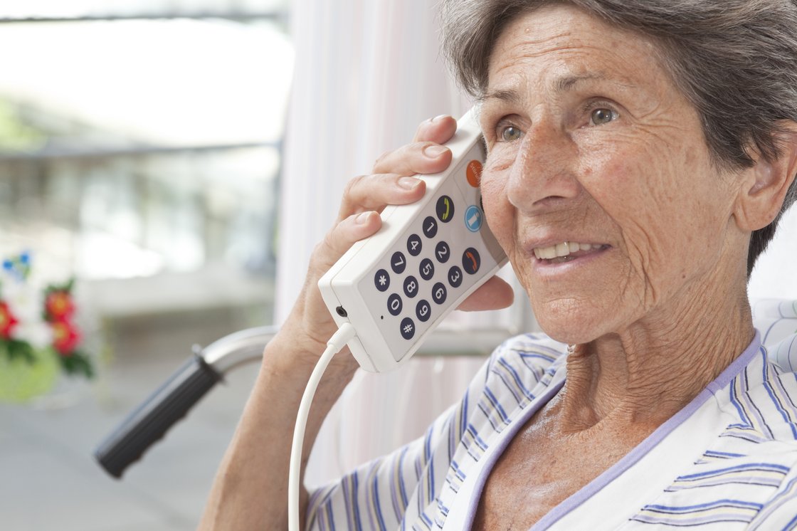 Eine Patientin telefoniert von ihrem Bett aus 