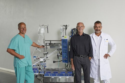 Operateur Professor Dr. Andreas Liebold (re.), zusammen mit seinem Patienten Gregor Sontheimer, dem Leitende Kardiotechniker Günter Albrecht (li.) und der Herz-Lungen-Maschine Foto: Universitätsklinikum Ulm/ Matthias Schmiedel  