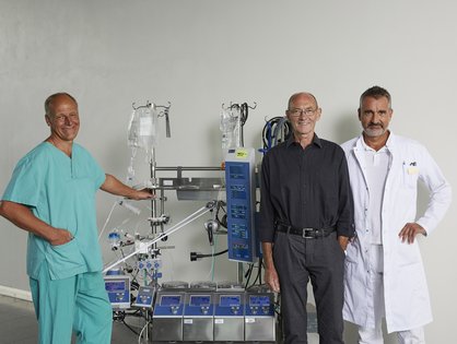 Operateur Professor Dr. Andreas Liebold (re.), zusammen mit seinem Patienten Gregor Sontheimer, dem Leitende Kardiotechniker Günter Albrecht (li.) und der Herz-Lungen-Maschine Foto: Universitätsklinikum Ulm/ Matthias Schmiedel  