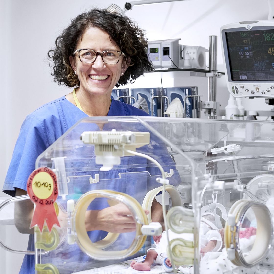 Eine Pflegekraft in der Geburtshilfe vor einem Inkubator