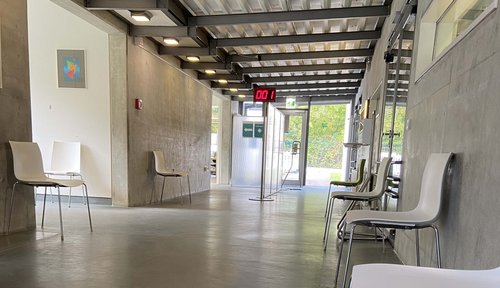Über eine digitale Anzeige im Wartebereich können Patient*innen verfolgen, wann sie aufgerufen werden.