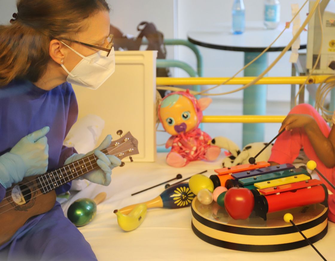 Quelle: Universitätsklinikum Ulm Die Musiktherapeutin am Patientenbett mit Gitarre
