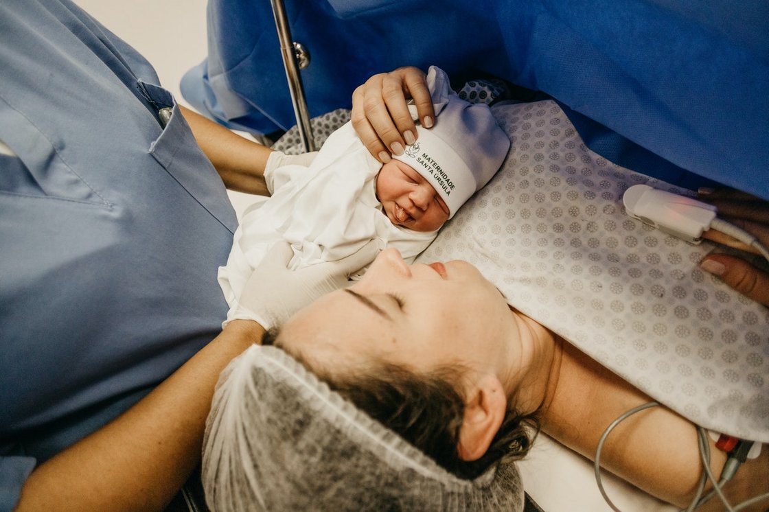 Frau mit Baby nach Kaiserschnitt