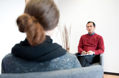 Ein Mann und eine Frau sitzen sich in einer Therapiestunde gegenüber