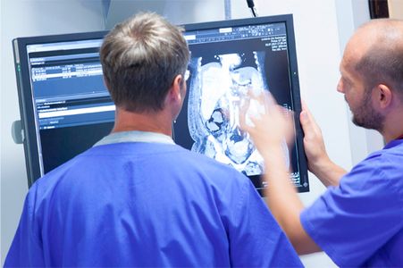Zwei Pflegekräfte besprechen ein Bild auf einem Monitor