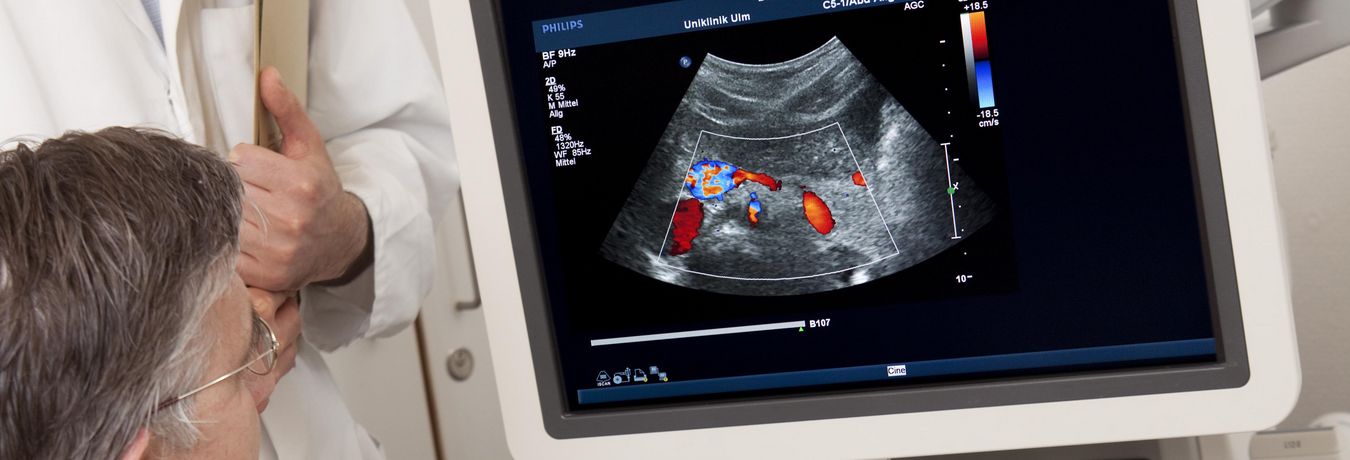 Ein Arzt schaut sich auf einem Monitor ein Ultraschallbild an 