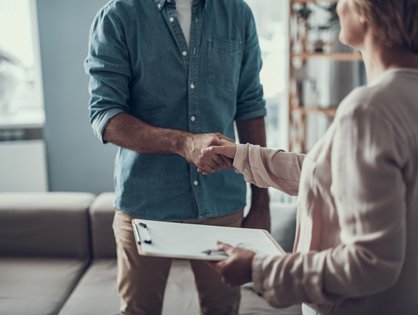 Eine Therapeutin gibt einem Patienten die Hand zur Begrüßung