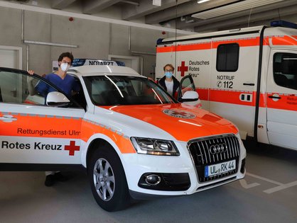 Ein Notarzt und ein NEF-Fahrer neben einem Notarztfahrzeug in der neuen Rettungswache