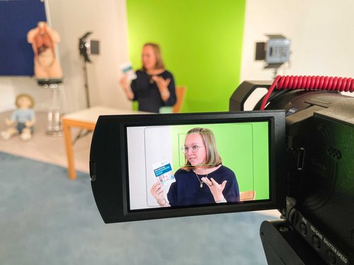 Eine Mitarbeiterin der Akademie berichtet vor der Kamera von den Ausbildungsberufen
