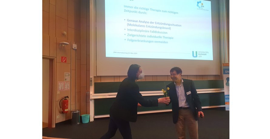Dr. Michaela Reichenzeller überreicht Prof. Dr. Johannes Weiss eine Pflanze, als Dank für seine Präsentation