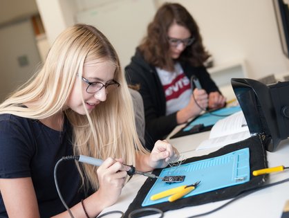 (Foto: Elvira Eberhardt): Mädchen löten beim Girls’Day an der Uni Ulm einen „Fernsehausknipser“ 