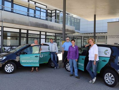 Das Team der Brückenpflege neben zwei E-Autos.