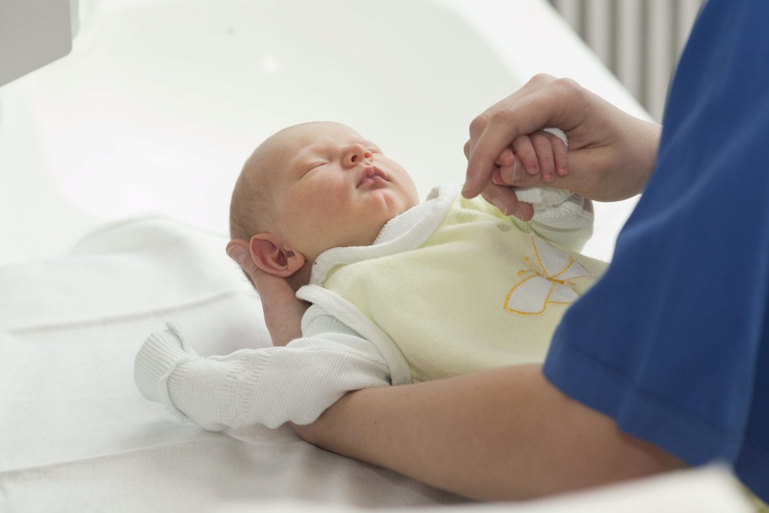 Kinderkrankenpflegerin versorgt Baby
